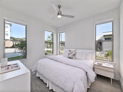 Beautiful apartment bedroom with windows and plush carpet.