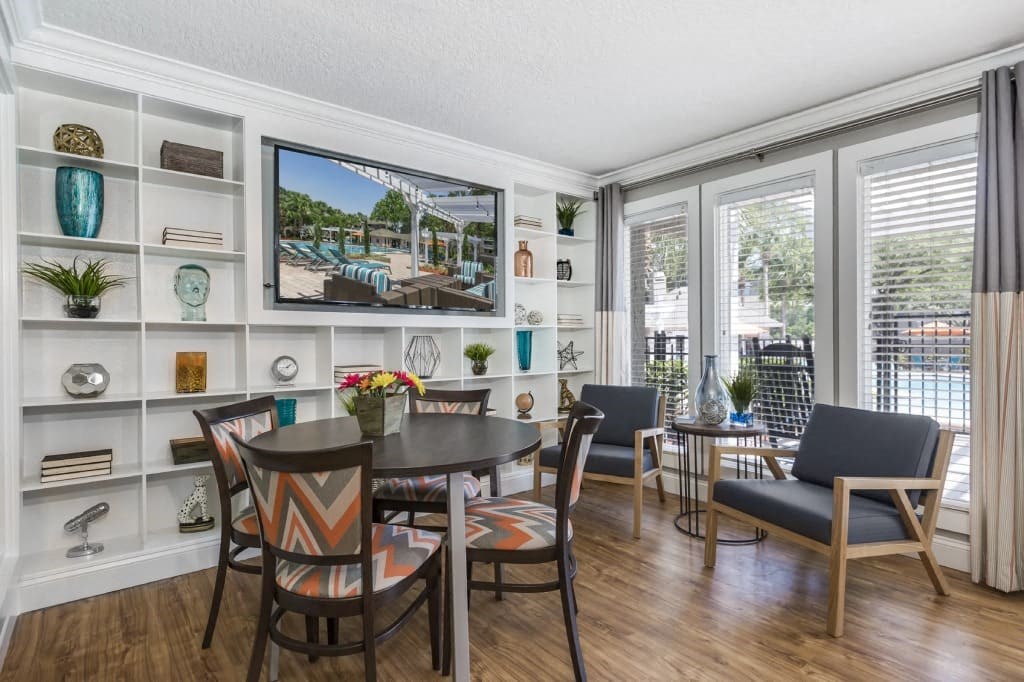 a living room with a table and chairs and a television