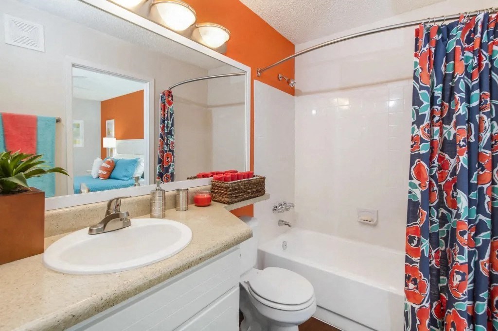 a bathroom with a shower and a sink and a toilet