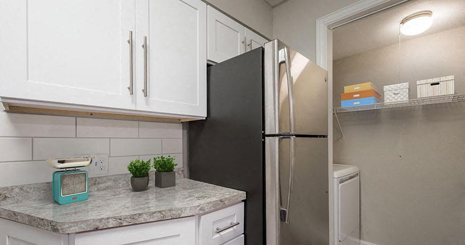a kitchen with a stainless steel refrigerator and white cabinets