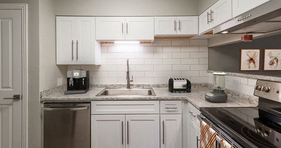 a kitchen with white cabinets and a sink