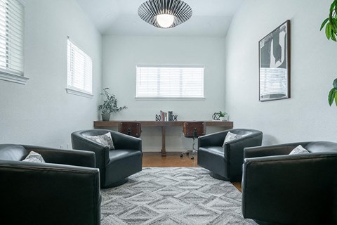 a living room with leather chairs and a rug
