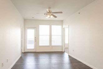 an empty living room with white walls and a ceiling fan