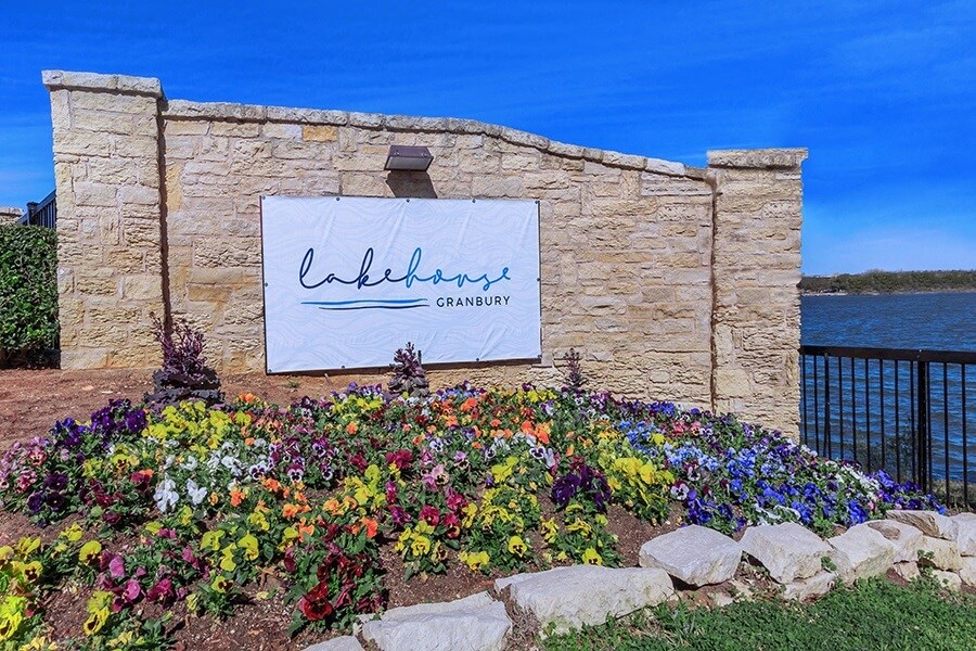 A stone wall with a sign that says "Lakebourn Cranberry".