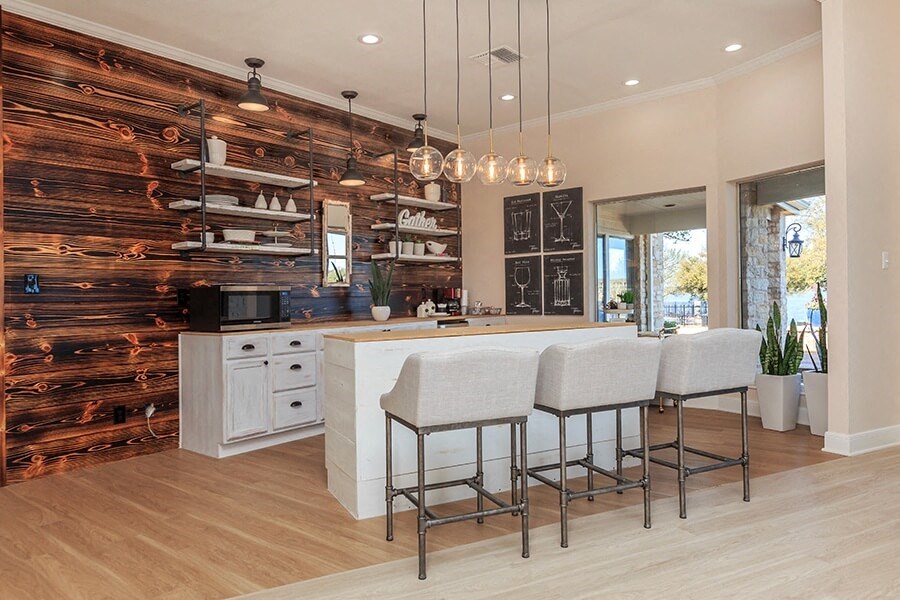 A kitchen with a wooden wall and white countertops.