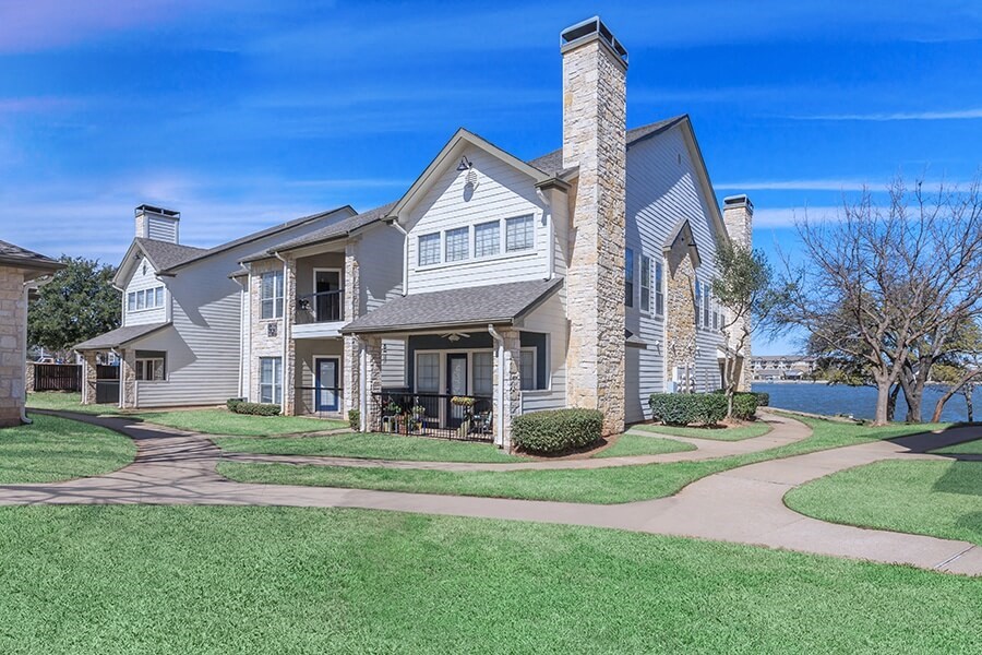 A large house with a stone chimney and a large front yard.