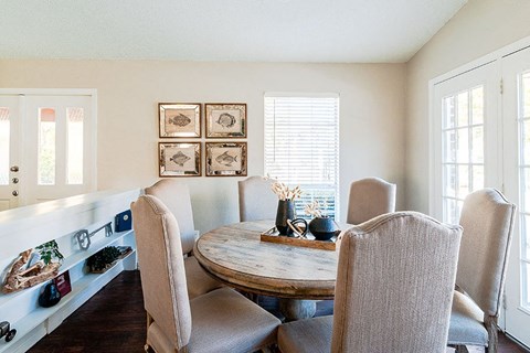 A dining room with a table and chairs.