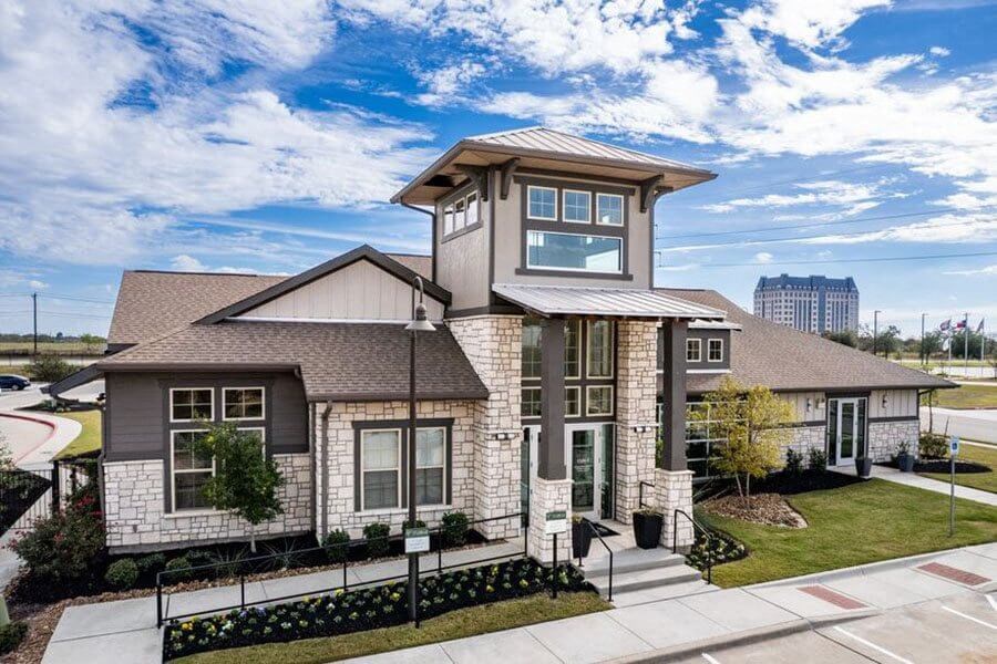 A modern house with a stone facade and a large front yard.