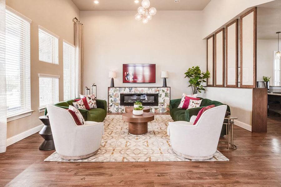 A living room with a fireplace and two white chairs.