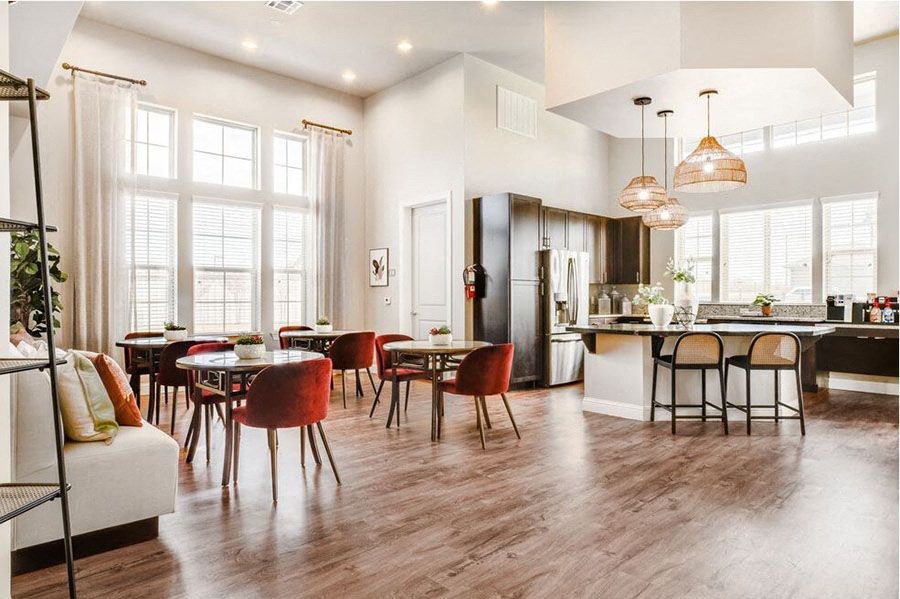 A modern kitchen and dining room with wooden floors and furniture.