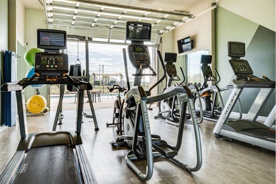 A gym with treadmills, exercise bikes, and other equipment.