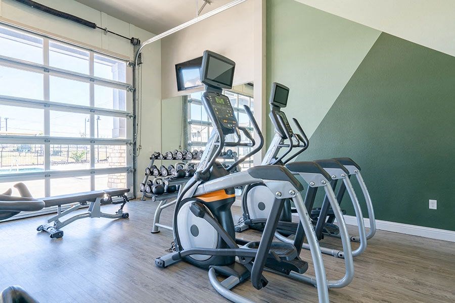 A gym with treadmills, elliptical machines, and other exercise equipment.