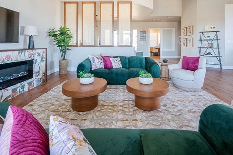 A living room with a green couch and a fireplace.