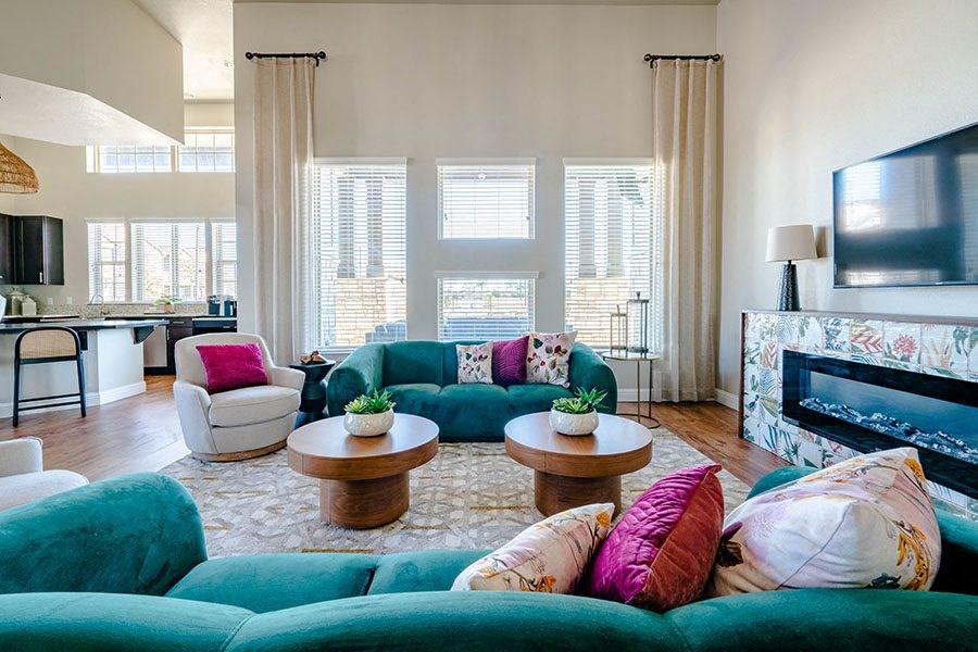 A living room with a green couch and a fireplace.