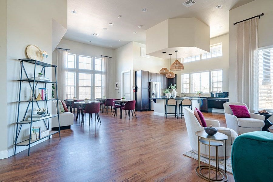 A large open living room with a dining area and a kitchen in the background.