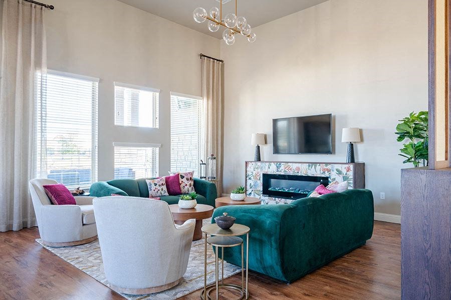 A living room with a green couch and a white chair.