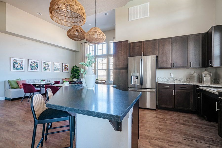 A kitchen with a blue countertop and a dining table with chairs.