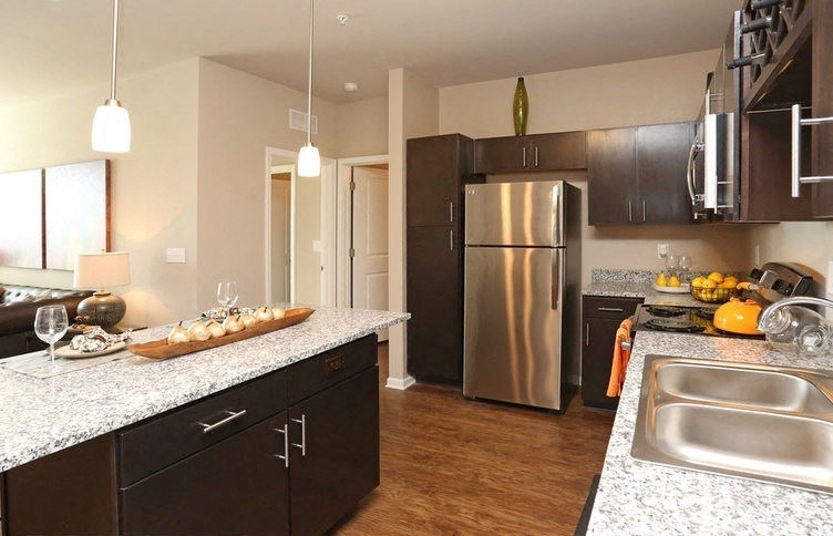 A kitchen with a refrigerator, sink, and countertop.