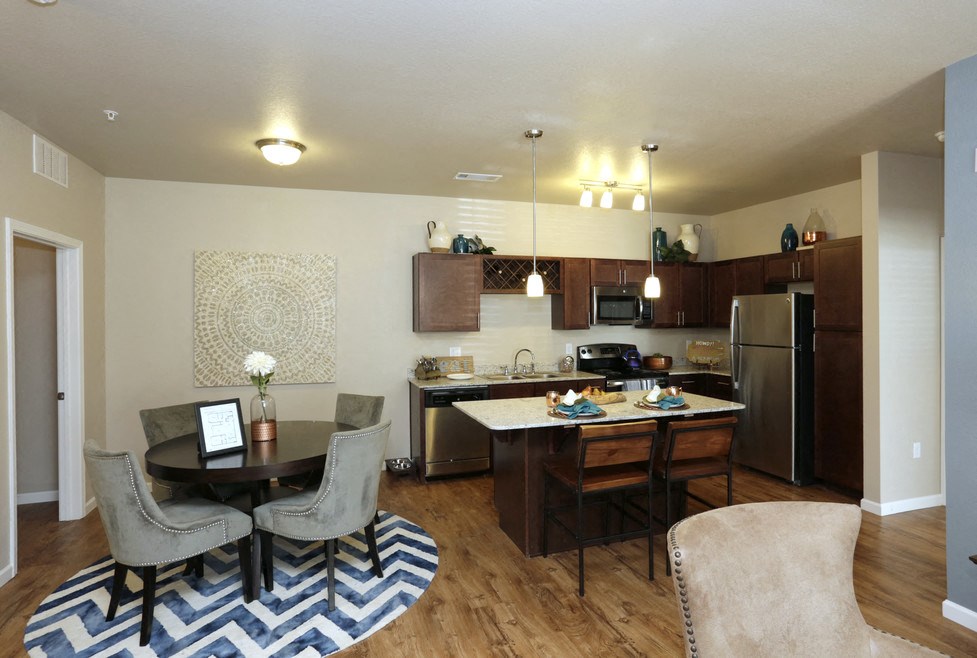 A kitchen with a dining table and chairs.