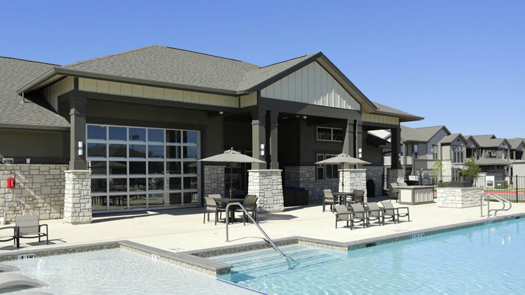 A large house with a pool in front.