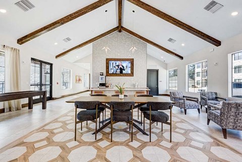 A large dining room with a wooden table surrounded by chairs.