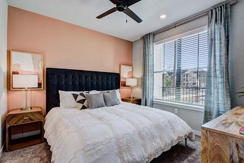 A bedroom with a large bed and a ceiling fan.