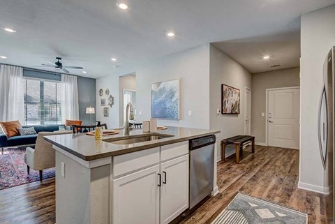 A kitchen with a large island and a refrigerator on the right.