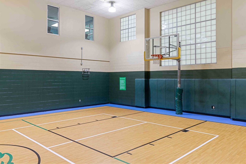 a basketball court in a gym with a basketball hoop