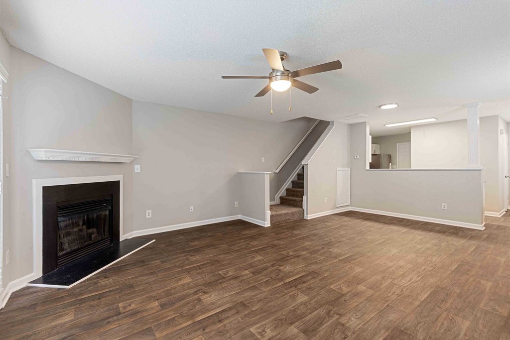a living room with a fireplace and a ceiling fan
