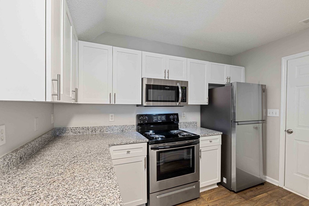 a kitchen with white cabinets and stainless steel appliances