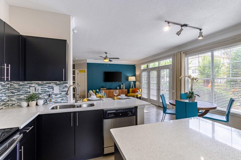A kitchen with black cabinets and a white countertop.