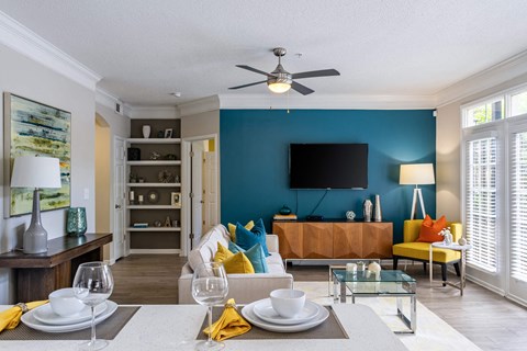 A modern living room with a dining table set for two.