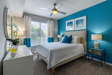 A bedroom with a bed, nightstand, and a ceiling fan.