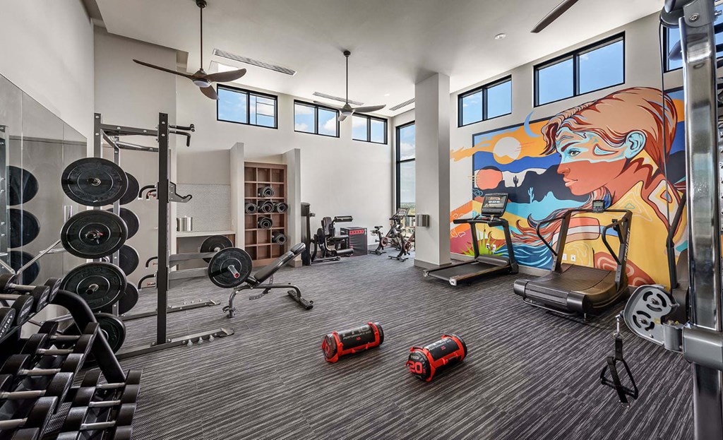 A gym with a variety of equipment including weights, a treadmill, and a stationary bike.