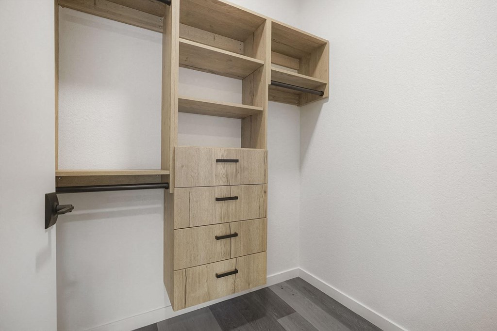 a closet in a bedroom with drawers and shelves
