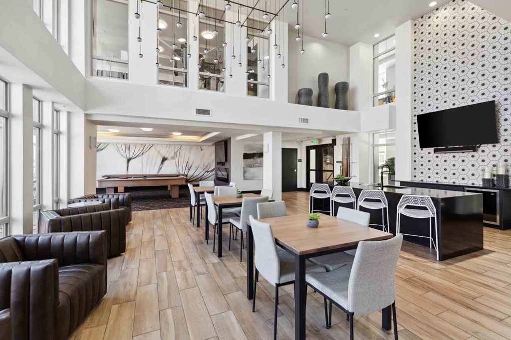 a large lobby with tables and chairs and a television