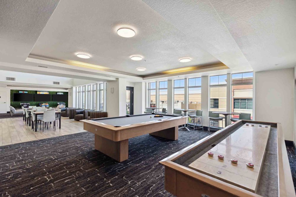 a community room with a pool table and a dining area