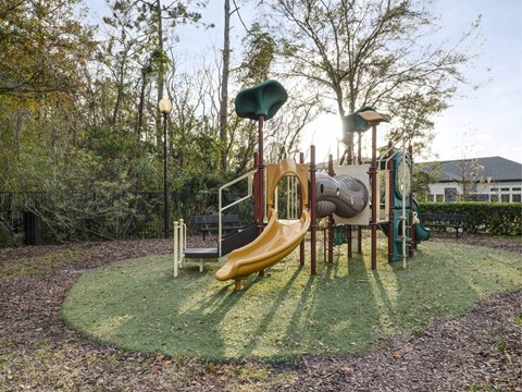 A playground with a yellow slide and a green top.