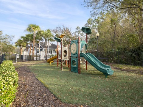 A playground with a green slide and a yellow slide.