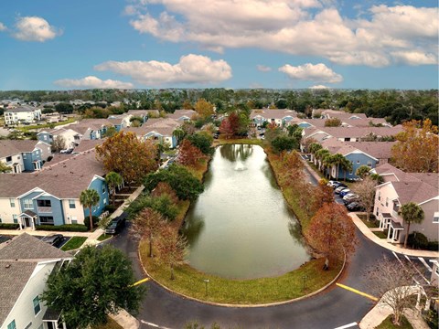 A residential area with a lake in the middle of the street.