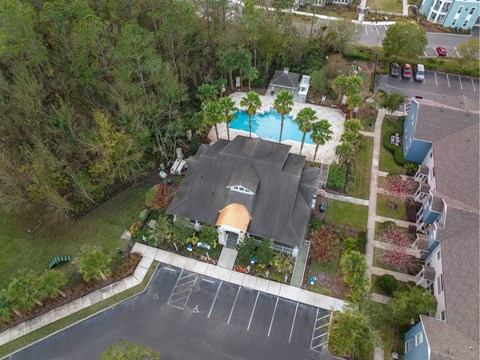 A pool surrounded by trees and a building with a yellow roof.