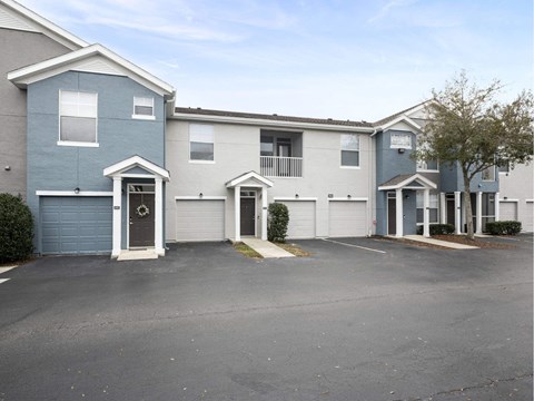A parking lot in front of a two-story apartment building.