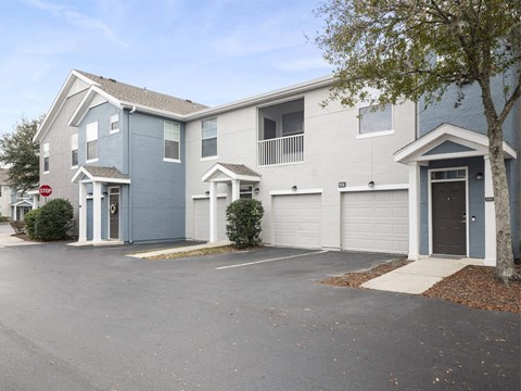 A row of houses with garages and driveways.