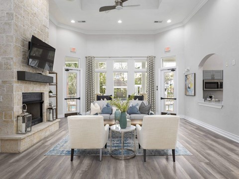 A living room with a stone fireplace and a television mounted above it.