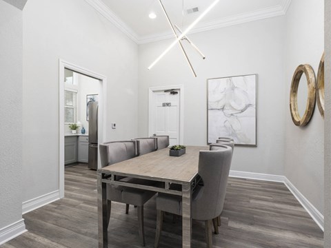 A dining room with a wooden table and grey chairs.