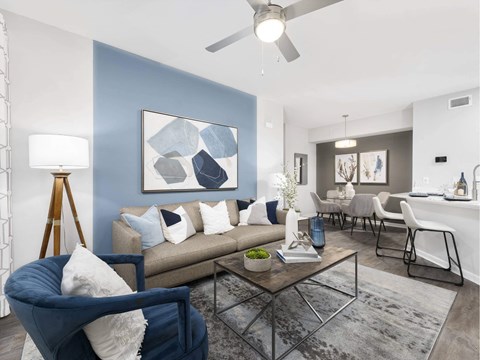 A living room with a blue chair and a grey couch.