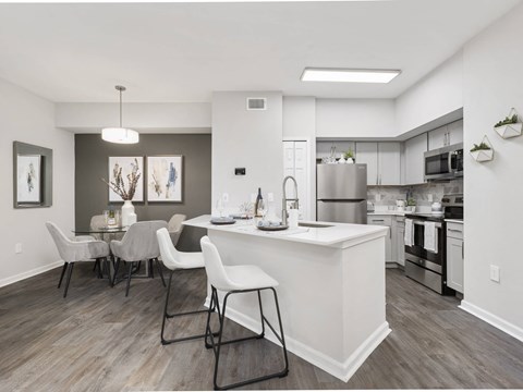 A modern kitchen with a dining table and chairs.
