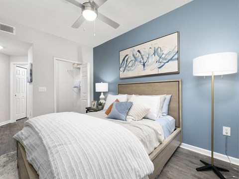 A bedroom with a large bed and a ceiling fan.
