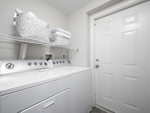 A white laundry room with a washer and dryer.