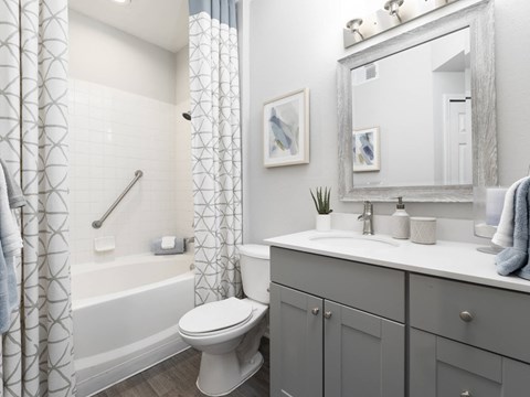 A bathroom with a toilet, sink, and mirror.